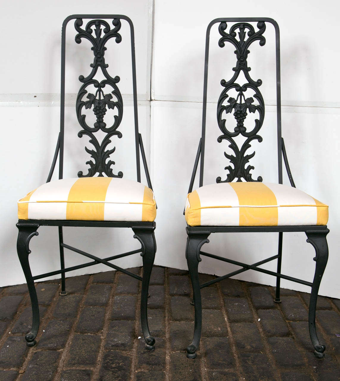 1960s Hollywood Regency black painted aluminum high back chairs. Newly reupholstered in Cowtan and Tout yellow and white striped fabric.