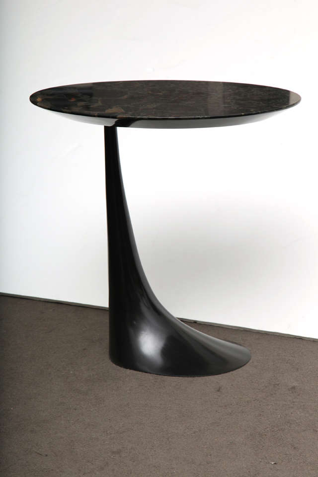 A side table by Hervé van der Straeten with a black beauty stone top and black patinated-bronze base.
 