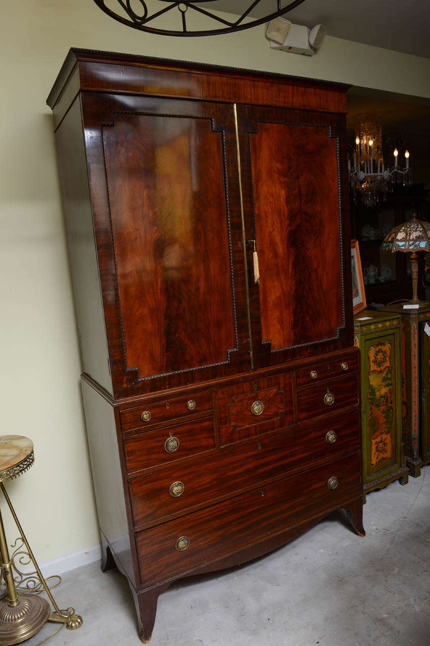 This is a Superb solid mahogany linen press or could be an entertainment center made in England circa 1860. The condition is very good with the original finish , this also has the original shelves to the inside as well as brass handles. The top has