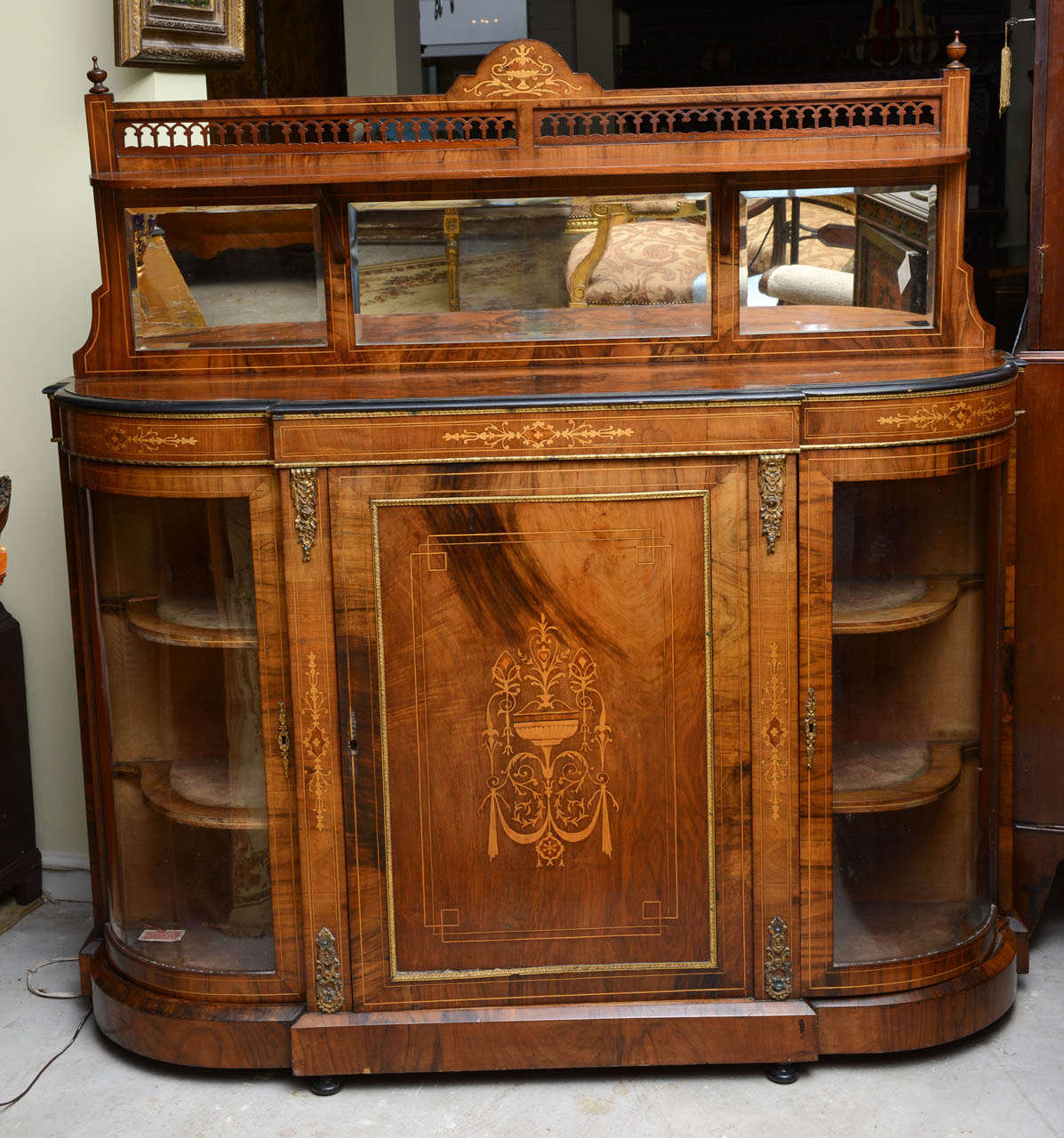This is a superb burr walnut credenza which could be used as either a server or console.
To the center door it has satinwood marquetry inlay either side on the doors it has satinwood string inlay.
The mirror back is very unusual most of these