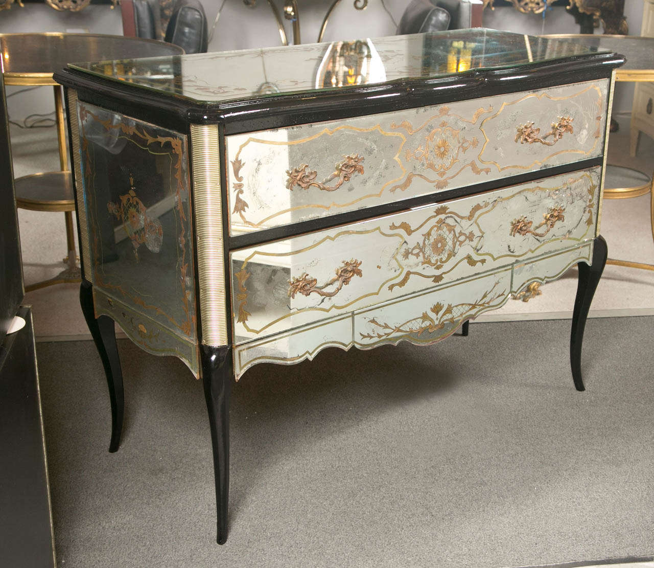 An alluring and exceptional French mirrored chest by Jansen, circa 1940s of Rococo taste, ebonized frame, the serpentine top over a conforming case fitted with two drawers, overall veneered with eglomise glass panels depicting of beautiful scrolls