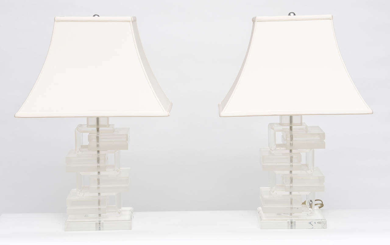 Pair of lamps with blocks of lucite stacked on alternating sides with a continuous lucite S running between. The continuous S is as wide as the blocks and is clear while the blocks are not. They are fantastic and will work well within a myriad of