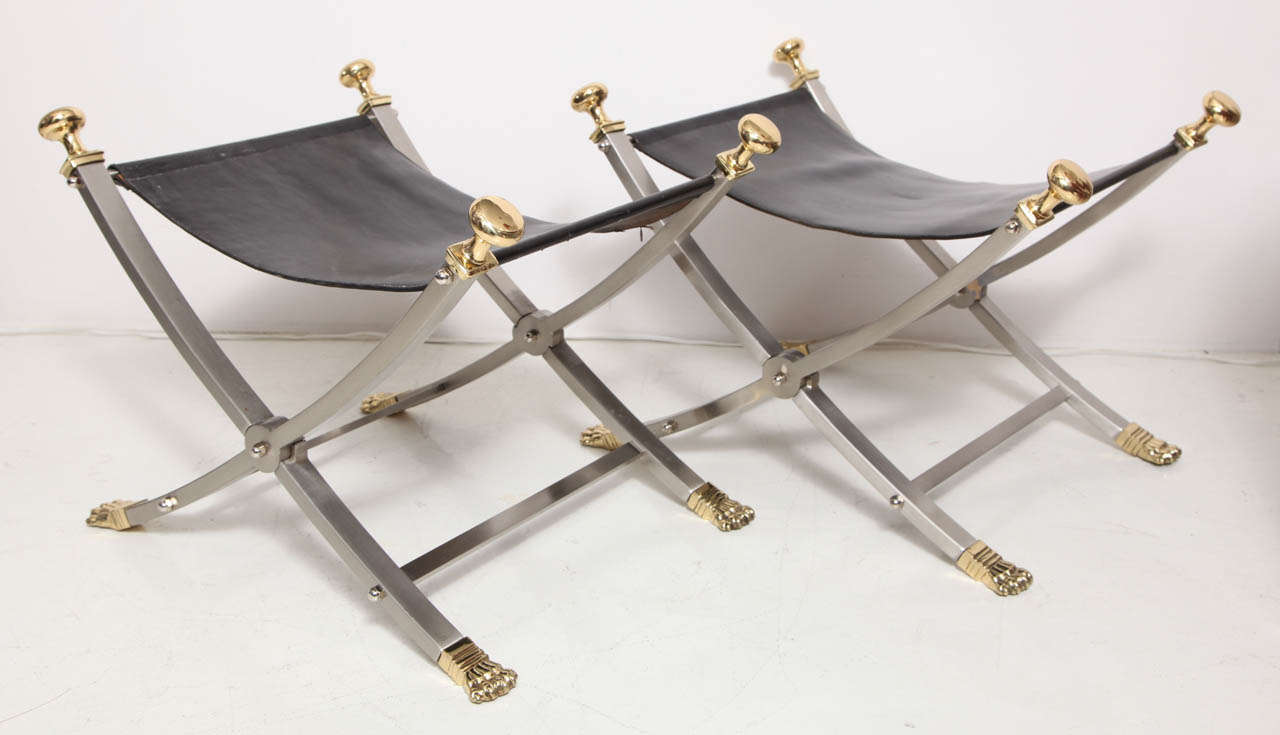 MAISON JANSEN
Pair of campaign style folding ‘x’ benches 
in steel with brass mounts and black leather upholstery.
French, c. 1960