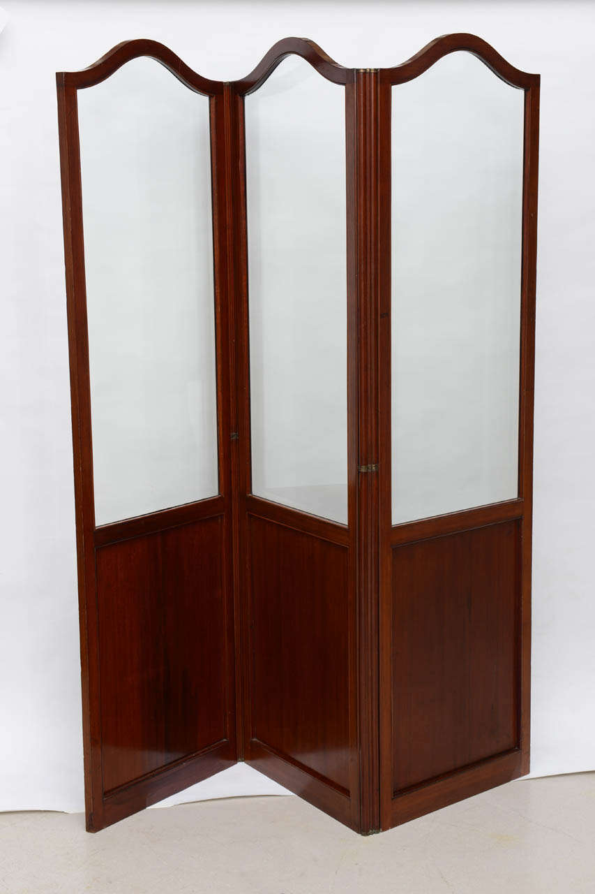 Mahogany three paneled folding screen with shaped beveled glass upper sections from France in the 1900's.