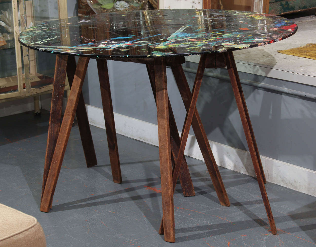 Wonderful collapsible/ portable table used by artist as work station. Heavy glass top sits atop three antique wood sawhorses that fold flat
beautiful piece of art just as it is.