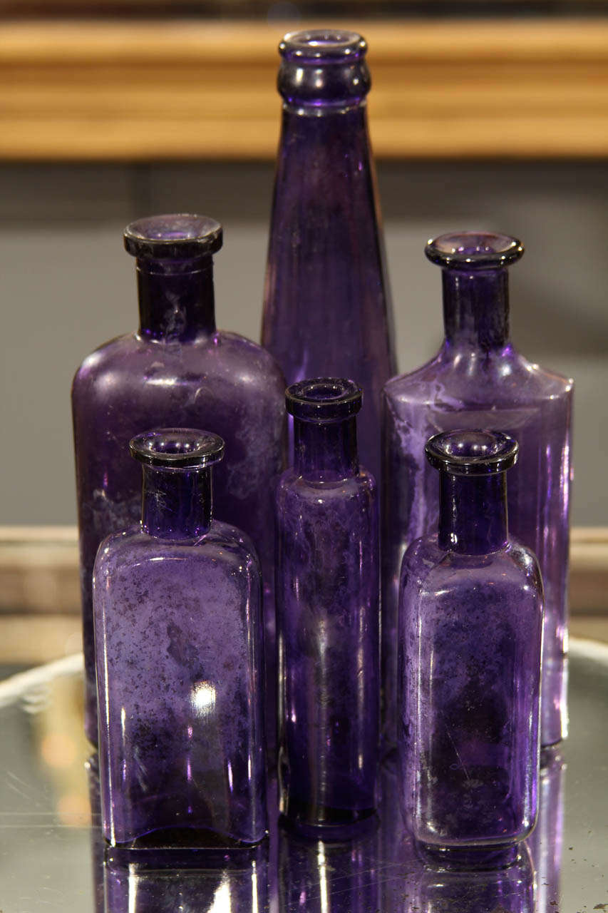 assortment of 6 assorted  antique purple bottles
good as vases or as decorative items on their own
