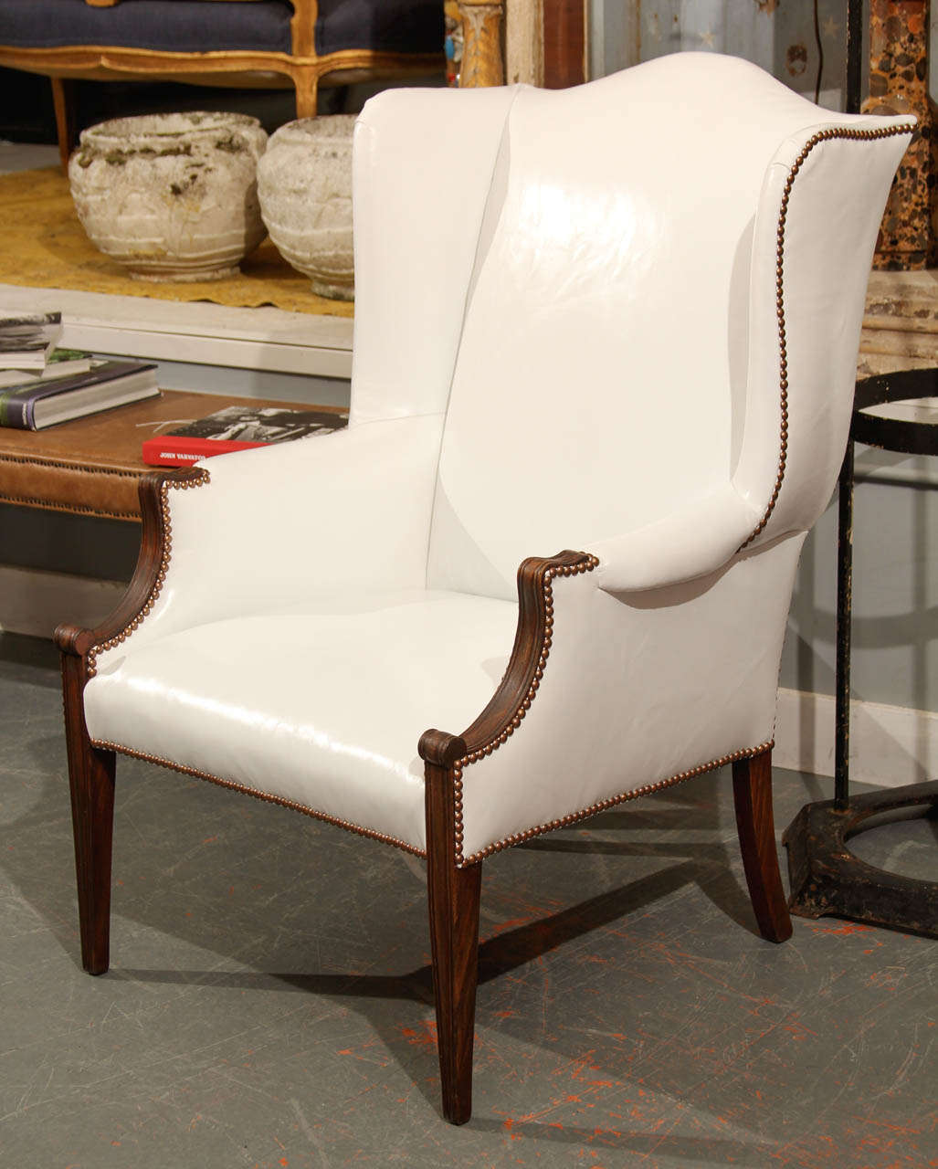 curvy white leather wing chair with nailhead trim.