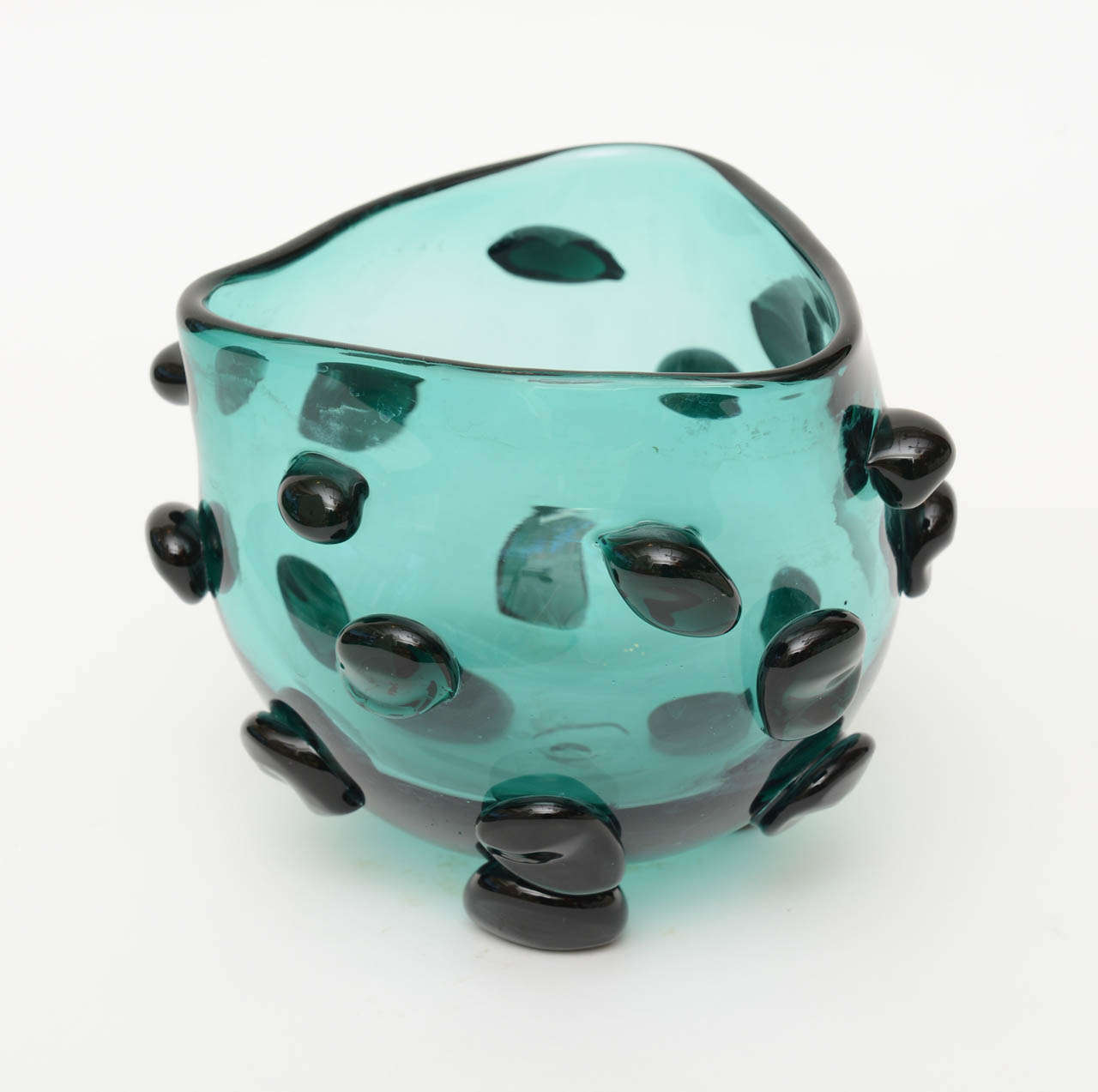 This fabulous bowl/vessel by Blenko has wonderful glass appendages attached in free form design.

it is a cross between teal blue and teal green.... depending on the light.
The glass appendages are a darker green black.
It is a piece of art and