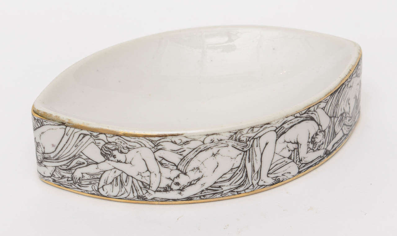 Fornasetti 's dream roman bather nymphs intertwine the facade of the almond shaped bowl...
a faint gold painted line rims the top and bottom.
The white porcelain bowl is perfect for serving almonds...