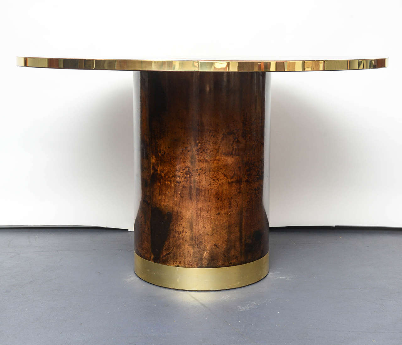 Brown lacquered goatskin, brass circled, the round base is in the same material.
The proportions of the gueridon is perfect for six people, could be as Gueridon or middle table.