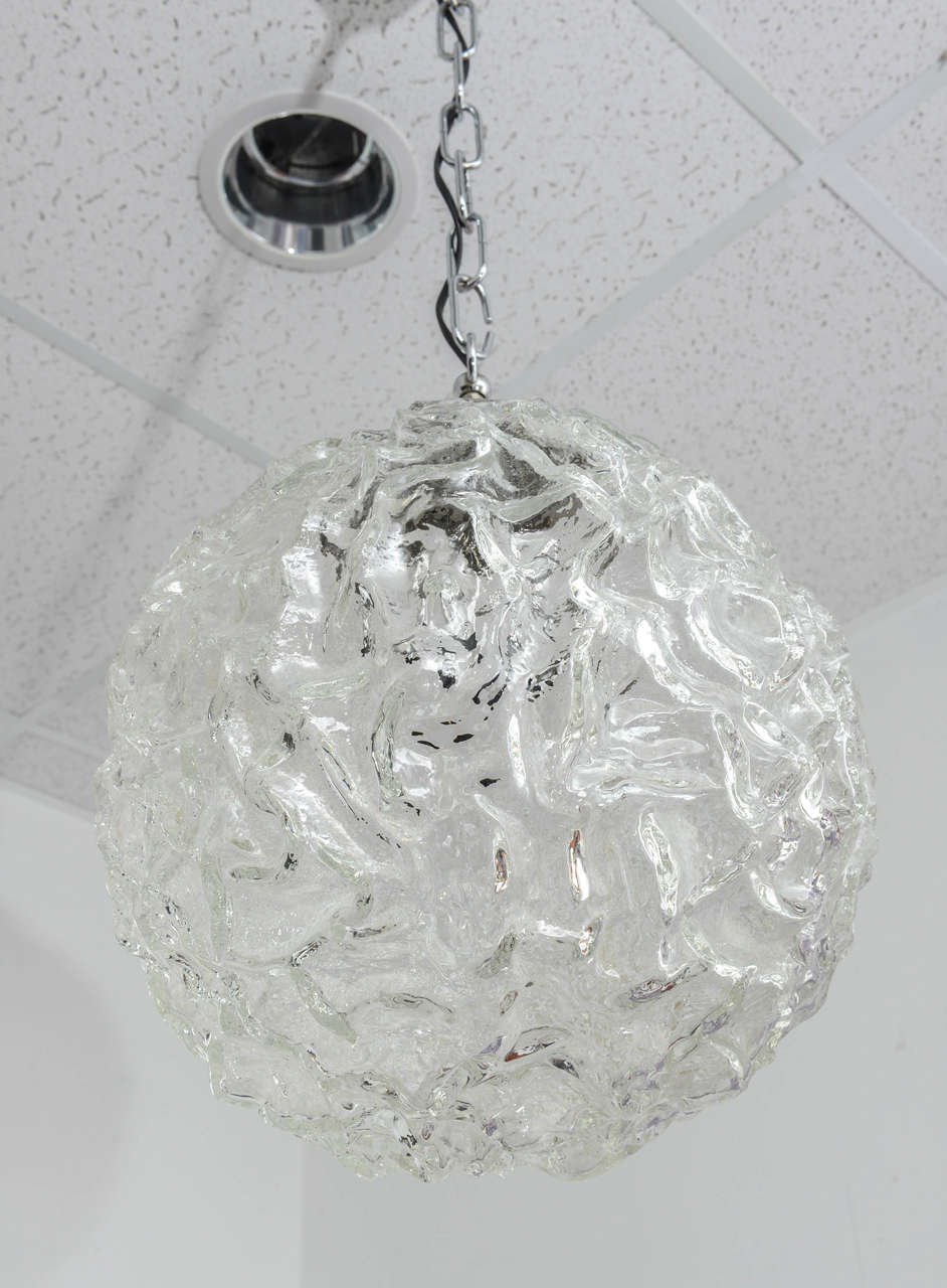 Thick waved Murano glass globe suspended by a chrome chain.
Simple shape and elegant proportion.