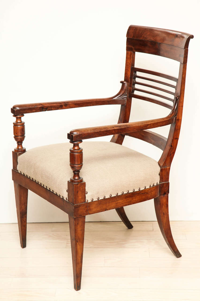 Pair of yew wood armchairs with turned front supports, a horizontal slated back and tapering legs.