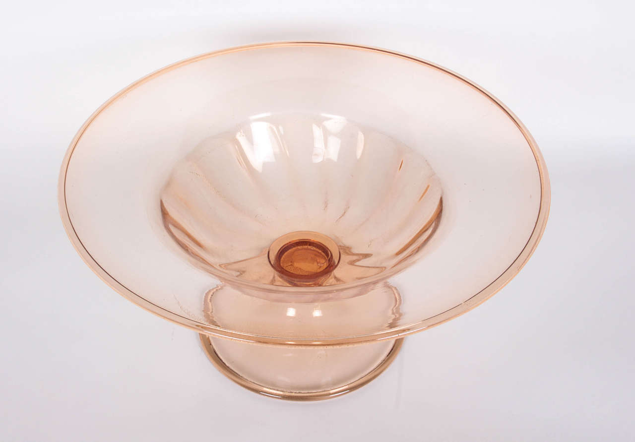 This blown-glass bowl in an unusual shade of orange is infused with gold leaf throughout. It is an early example of the model introduced around 1928 by Venini's art director Napoleone Martinuzzi. Another example in purple, without the gold leaf, is