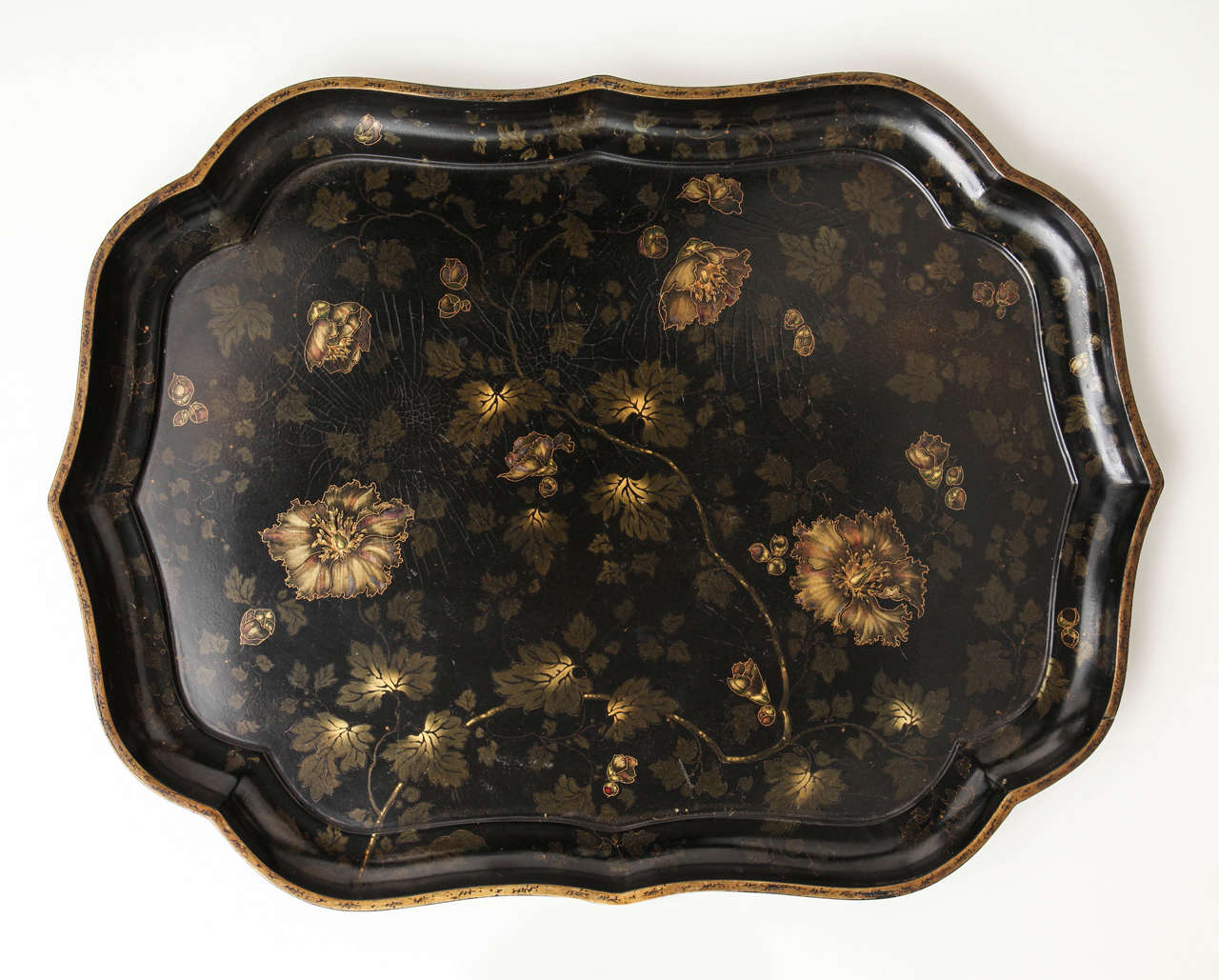 A 19th century English shaped papier mâché tray with polychrome and gilt-decorated trailing floral decoration, stamped Jennens & Bettridge's London with a Royal Warrant Crown, circa 1850