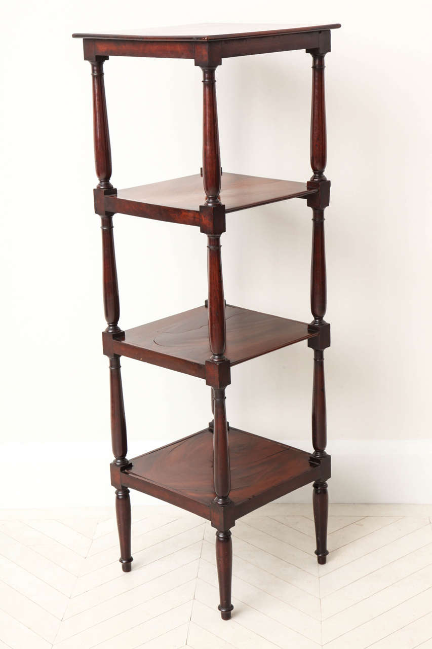 An English Regency mahogany four-tier whatnot (etagere) with elongated columnar supports, circa 1820.