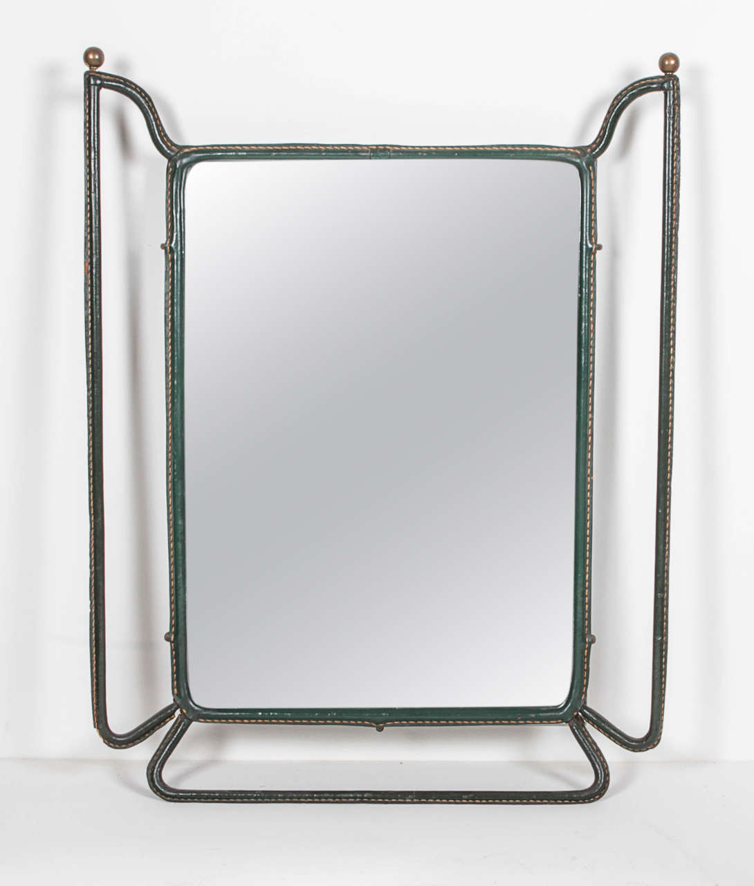 Jacques Adnet,  Circa 1955
Rectangular Mirror and Magazine stand  in tubular metal covered in dark green leather with top stitched detail.