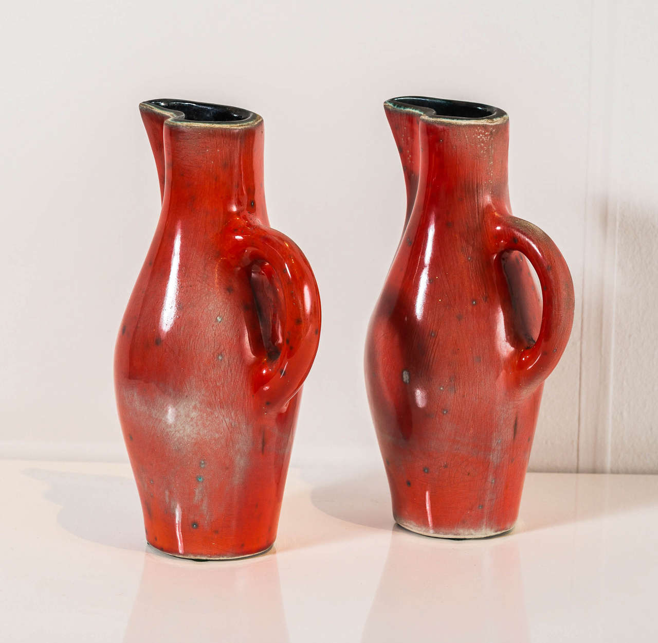 "Pichets Rouges" - A rare pair of red and black, glazed ceramic pitchers.
Underside incised with "Apollon" artist's mark and Jouve.  France, circa 1955.
Literature: M. Fare "Jouve Ceramiste" Paris, 1955, P. 70 for a