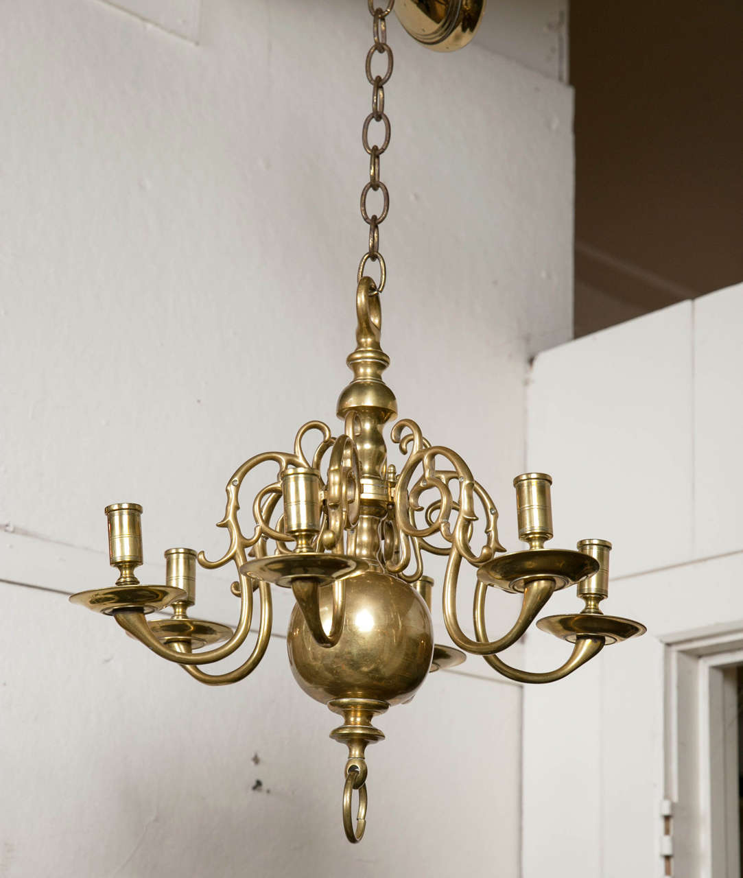 This simple yet elegant six-arm chandelier has never been wired for electricity.
Each arm lettered to fit the proper lettered slot in the center shaft. Each stamped A to F. Flattened ring above the sectioned center, with a large brass ball below