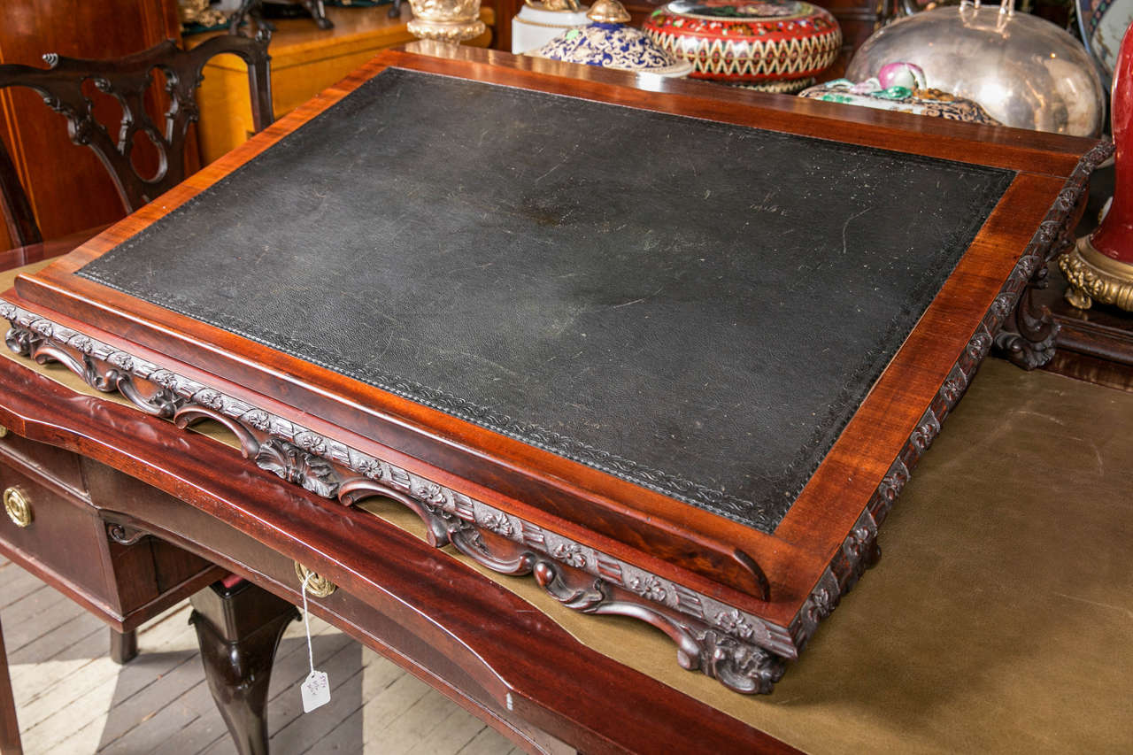 Made of solid mahogany with a tooled leather top, this stand slants up from the front book ledge to the rear. Gadrooned edge, intricate carvings all around. The book ledge is removable.