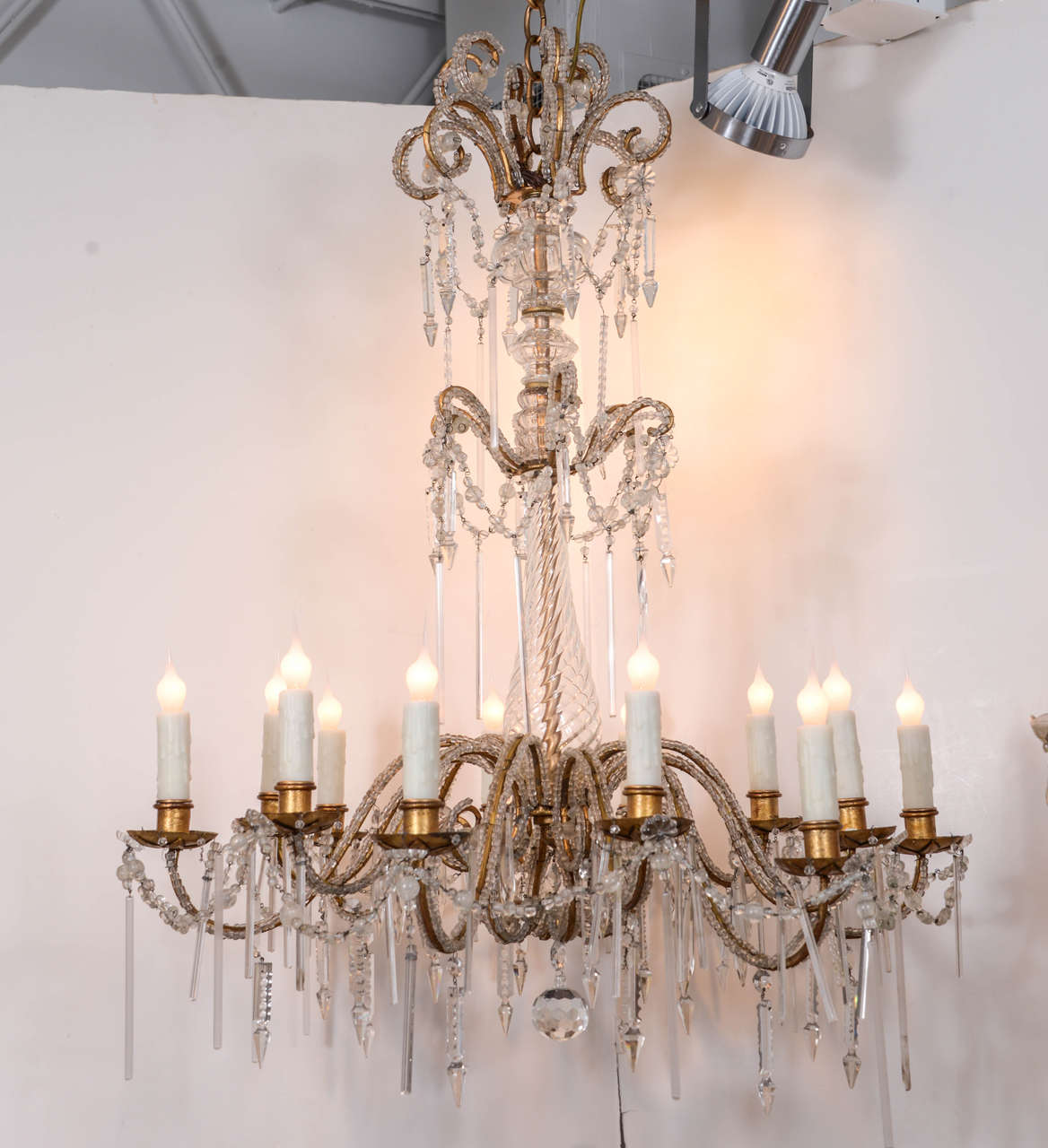 Italian chandelier with cut crystal body, crystal pendants and 12 beaded gilt iron arms, newly wired with extra chain and a canopy, circa 1920s.