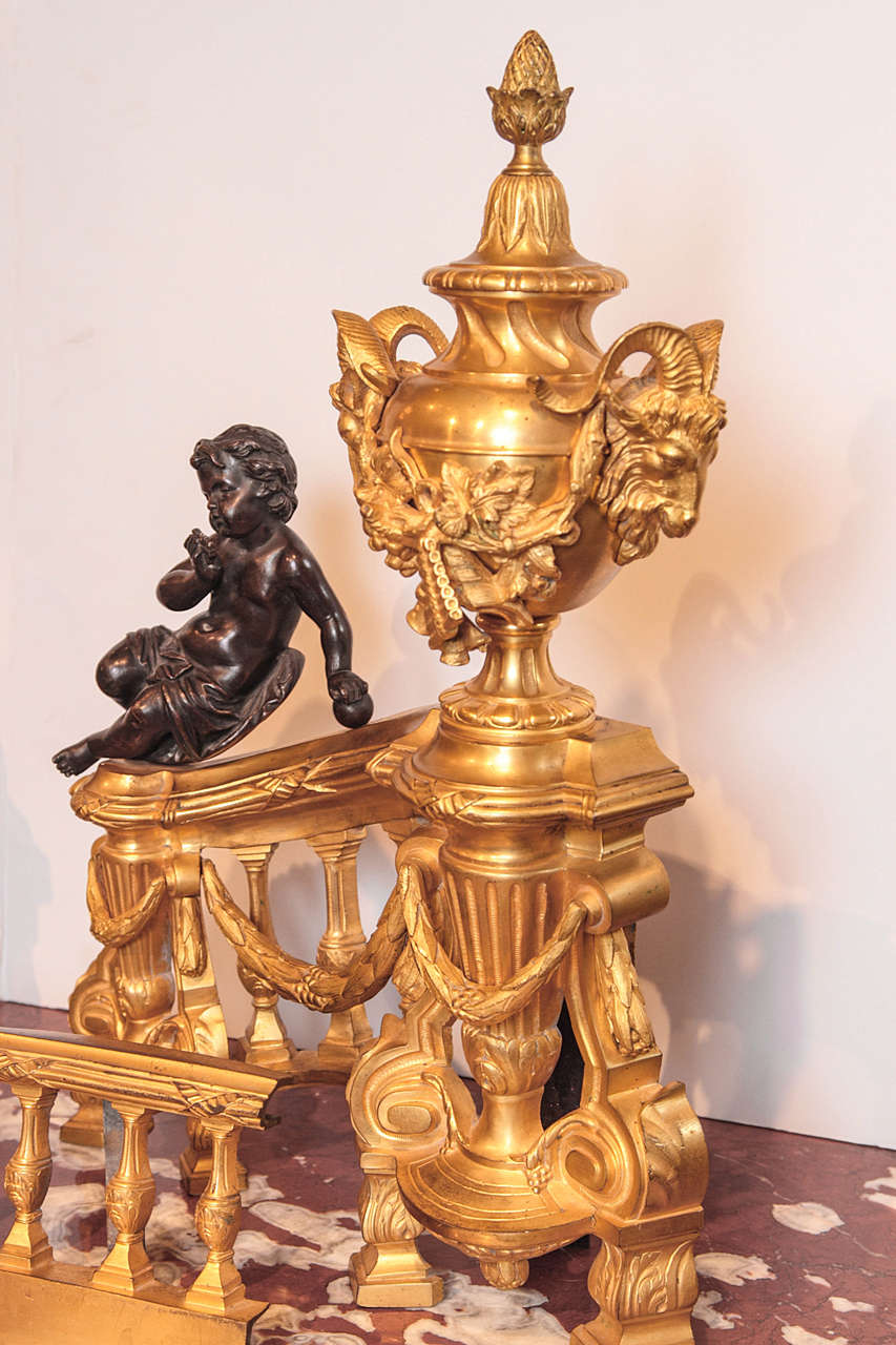 19th century French gilt bronze cherub chenets. Large with fine detail and patinated cherubs sitting atop the chenets. Louis XVI rams head details throughout