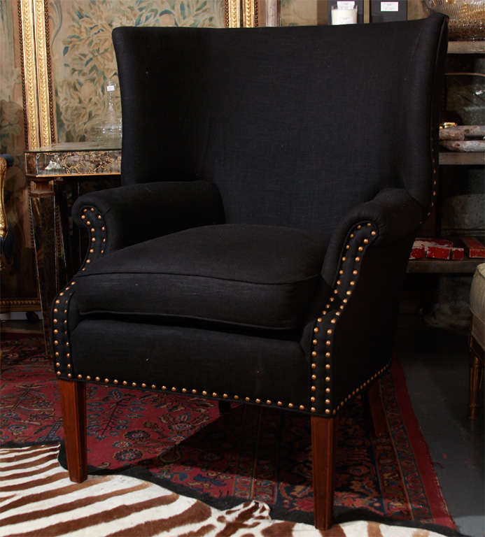 very comfortable and handsome wingback chair reupholstered in black linen accented with nailheads