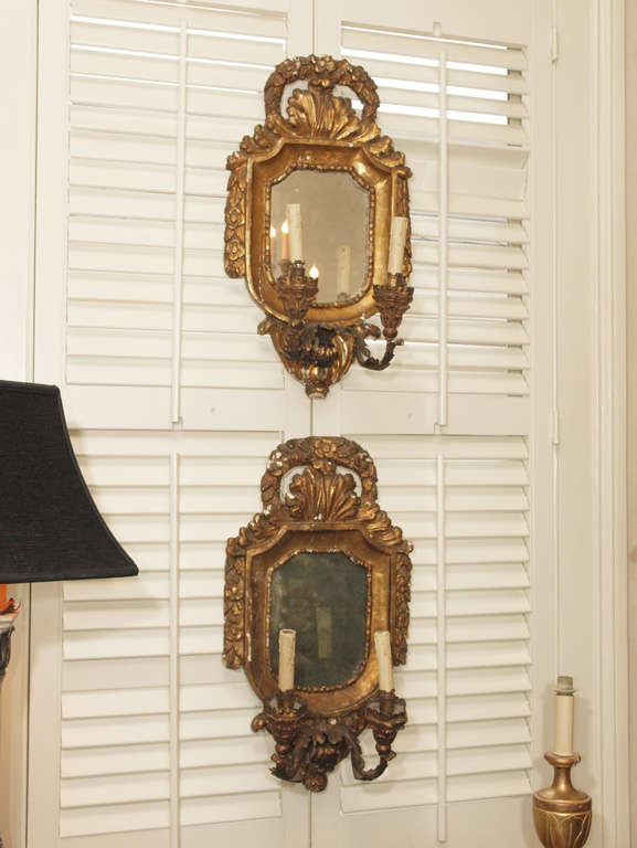 Pair of large 18th century Italian giltwood two-light wall sconces with mirror.