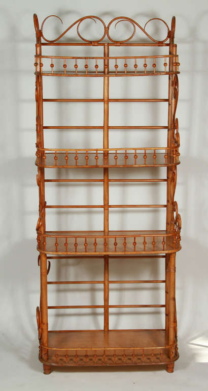 vintage bent rattan four tier shelving with stick and ball rail around each shelf.