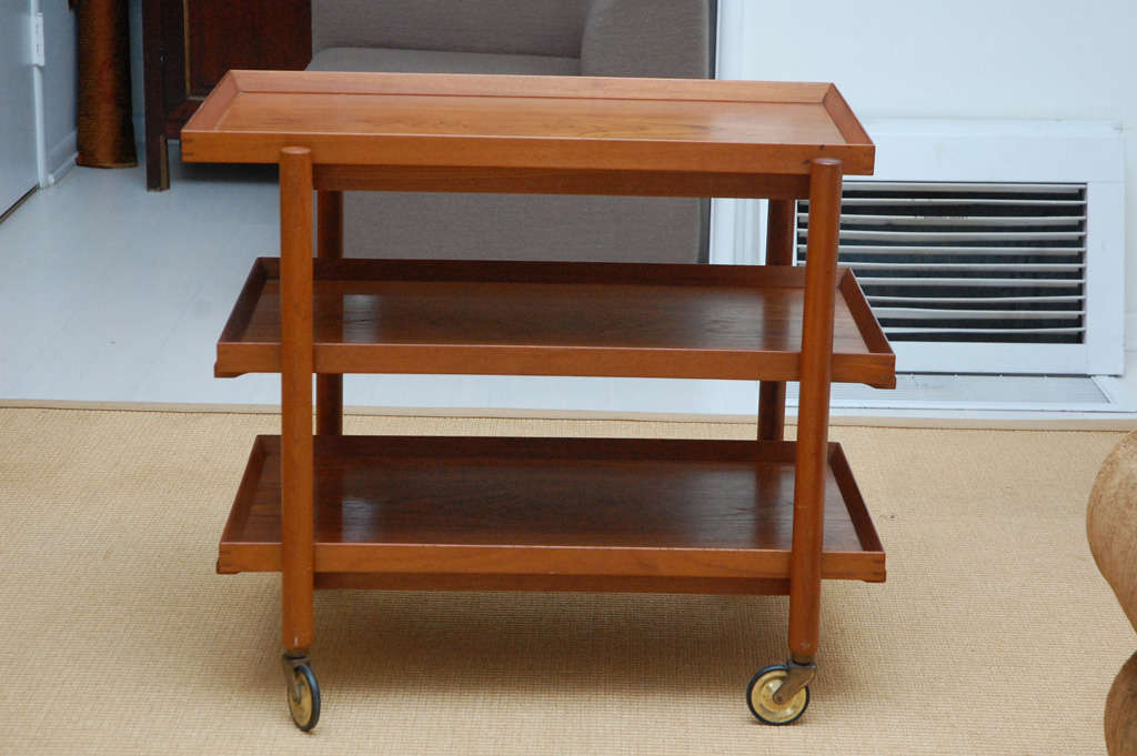 Wonderful vintage teak trolley that not only serves perfectly as a beverage cart with modular shelves, but as a stationary media stand, as well. Top opens to accommodate two shelves side by side, doubling as a functional server.