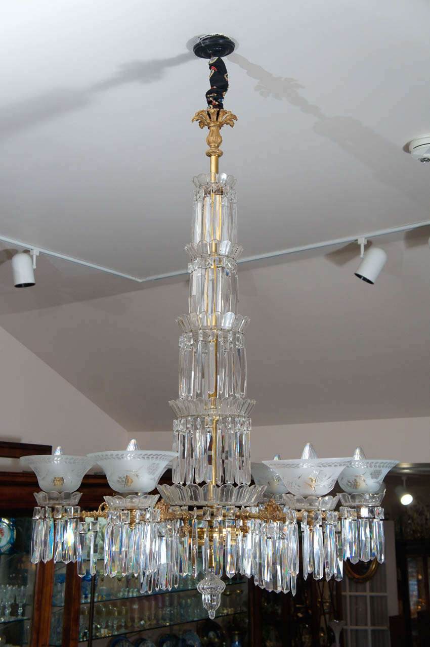 This incredible American Gasolier is cut crystal with four graduated tiers of prisms encircling the central post and 6 lights with original frosted glass shades. Each shade is also wheel cut and each light is decorated with cut crystal bobeches and