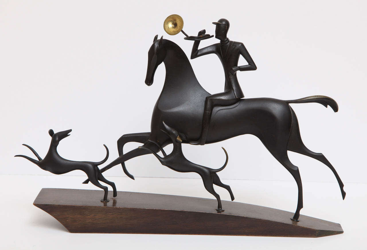A exceptional sculpture by Franz Hagenauer (1906-1986) depicting a hunter and his pair of hounds. Beautifully designed out of patinated bronze with a mahogany plinth.   Signed Hagenauer.