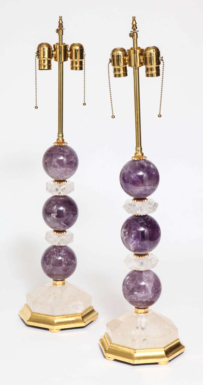 Unusual Pair of Hand-Carved Rock Crystal and Amethyst Rock Crystal Lamps Mounted with 24 Karat Gold Gilt Wood Bases. The rock crystal is cut into spheres and geometric shapes. 

Dimensions 
Height with Electric 30