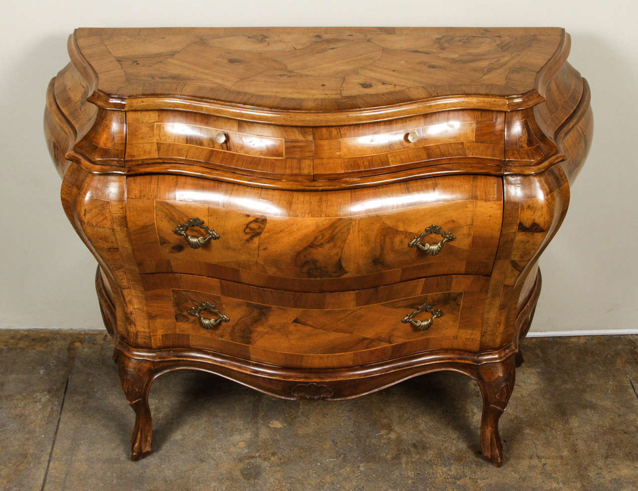 Beautiful four-drawer bombe chest made with burled olive. Incredible condition!