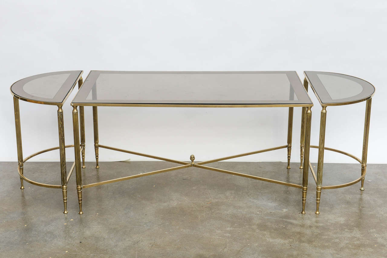 Sleek neo classically designed brass three piece set with mirrored edge smoked glass tops.