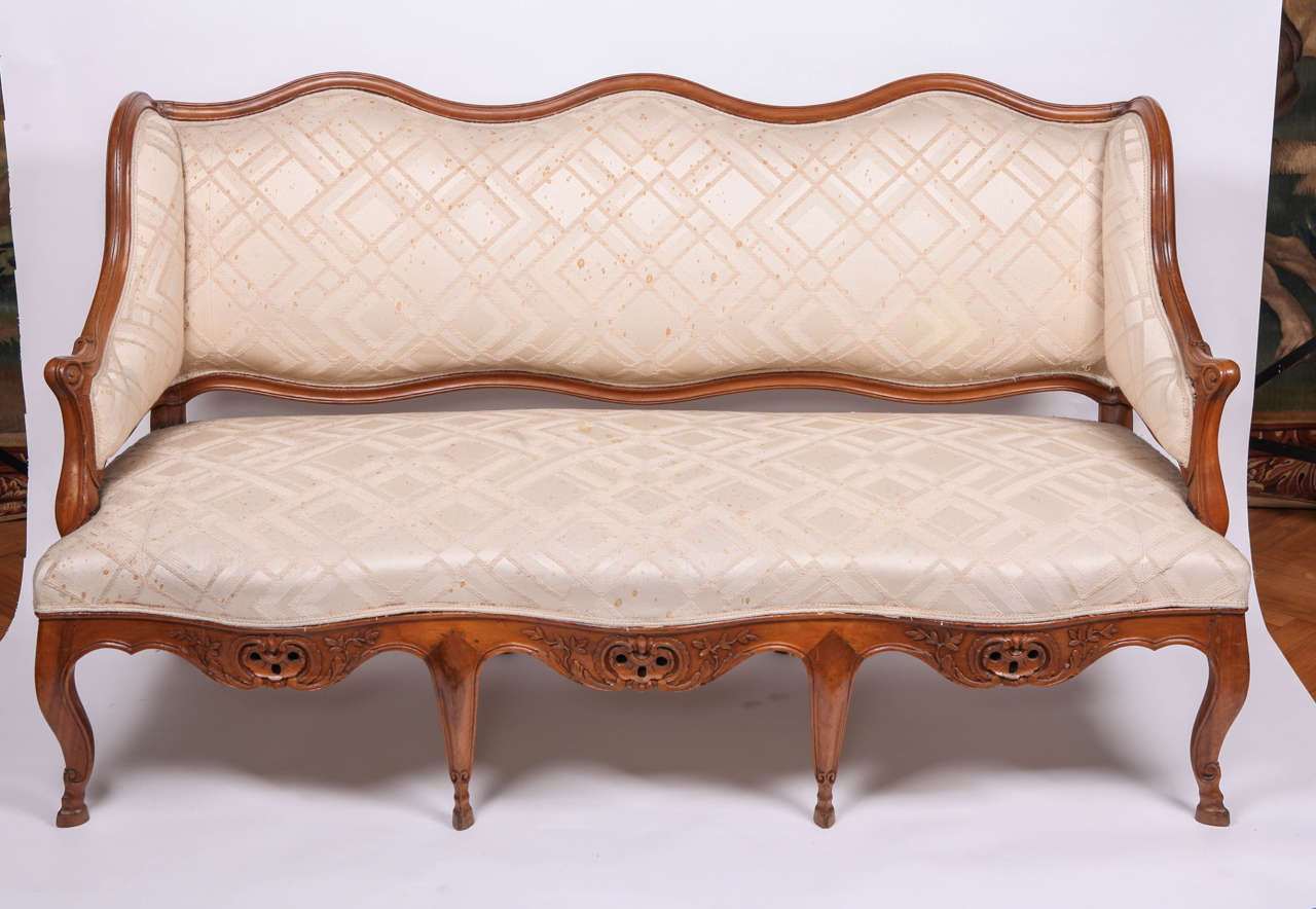 A FINE FRENCH 18th CENTURY CARVED WALNUT CANAPE WITH A SHAPED BACK , SCROLLING ARMRESTS ON A SERPENTINE SEAT ON CABRIOLE LEGS ENDING IN SCROLL FEET. CM 165X90X65