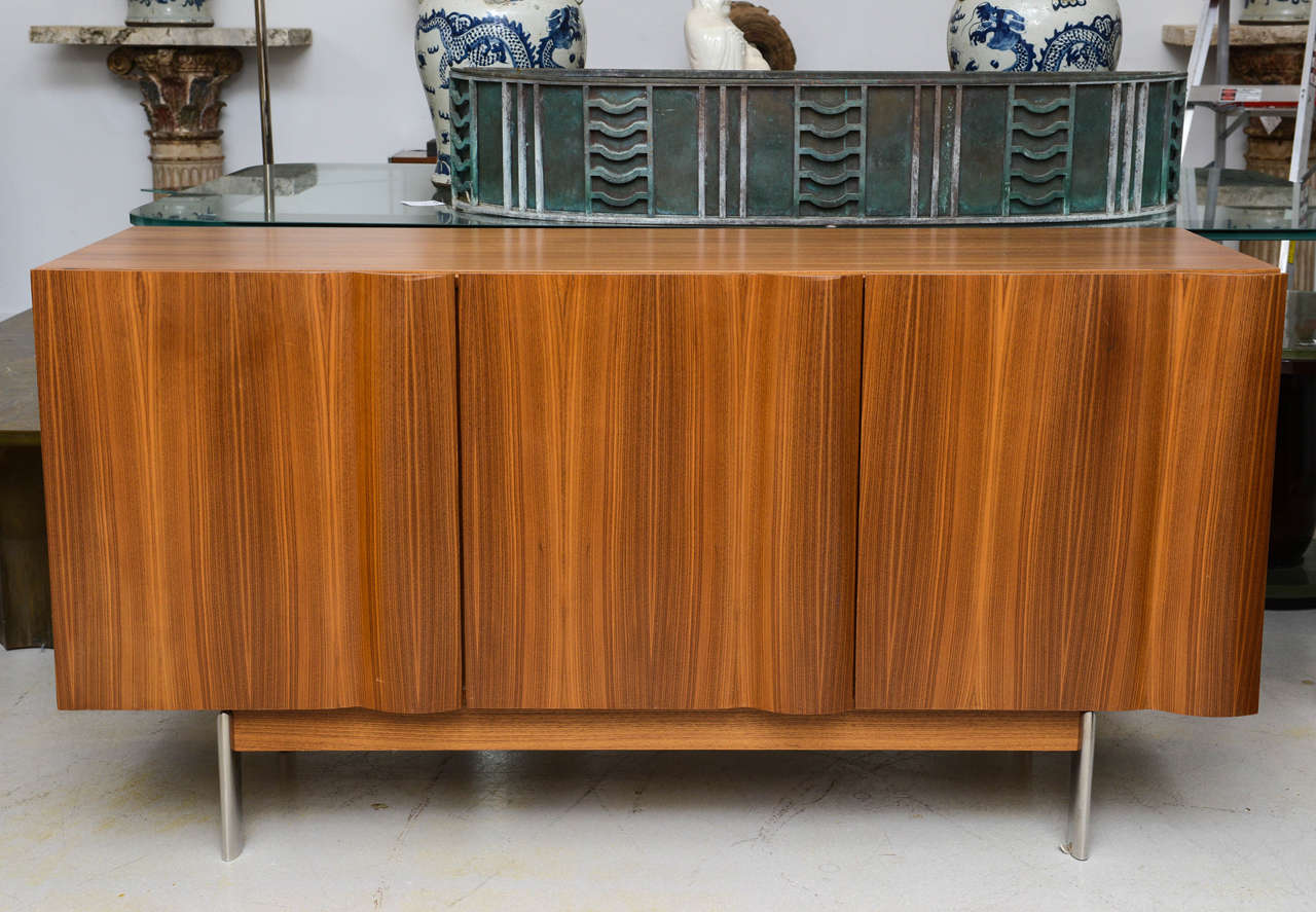 Dakota Jackson cabinet with undulating wave façade. The three doors open to reveal a fitted interior with shelves.
