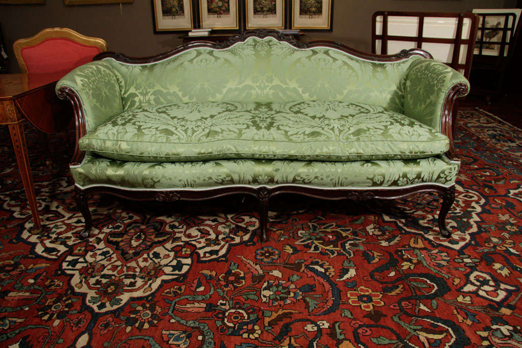 With foliate scroll-carved crestrail above green silk upholstered back, seat and sides, on cabriole<br />
legs.<br />
<br />
Provenance<br />
The Estate of Richard V. Hare; Sotheby's, New York, 3 October 2003, lot 120.