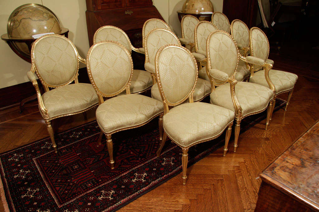 A SET OF TWELVE ENGLISH GILTWOOD CHAIRS,<br />
INCLUDING SEVEN GEORGE III ARMCHAIRS, CIRCA 1775, POSSIBLY BY JOHN LINNELL, TOGETHER WITH ONE ARMCHAIR AND FOUR SIDE CHAIRS EN SUITE, LATE 19th / EARLY 20th CENTURY<br />
<br />
Comprising of eight