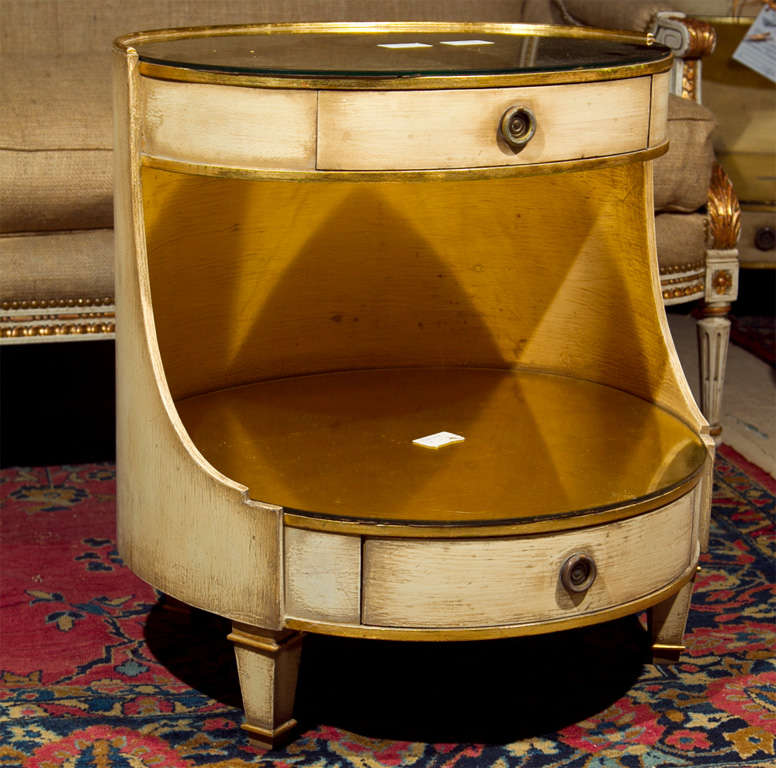 Unusual and rare pair of Maison Jansen painted with gilt highlights oval night stands. Both shelves are gold leaf glass.<br />
Both with one drawer.
