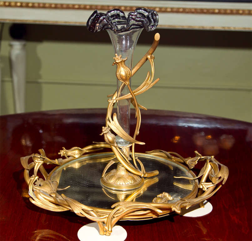 An exquisite 19th century French Epergne, decorated with beautiful bronze doré and a glass centerpiece, supported by a mirrored plate.