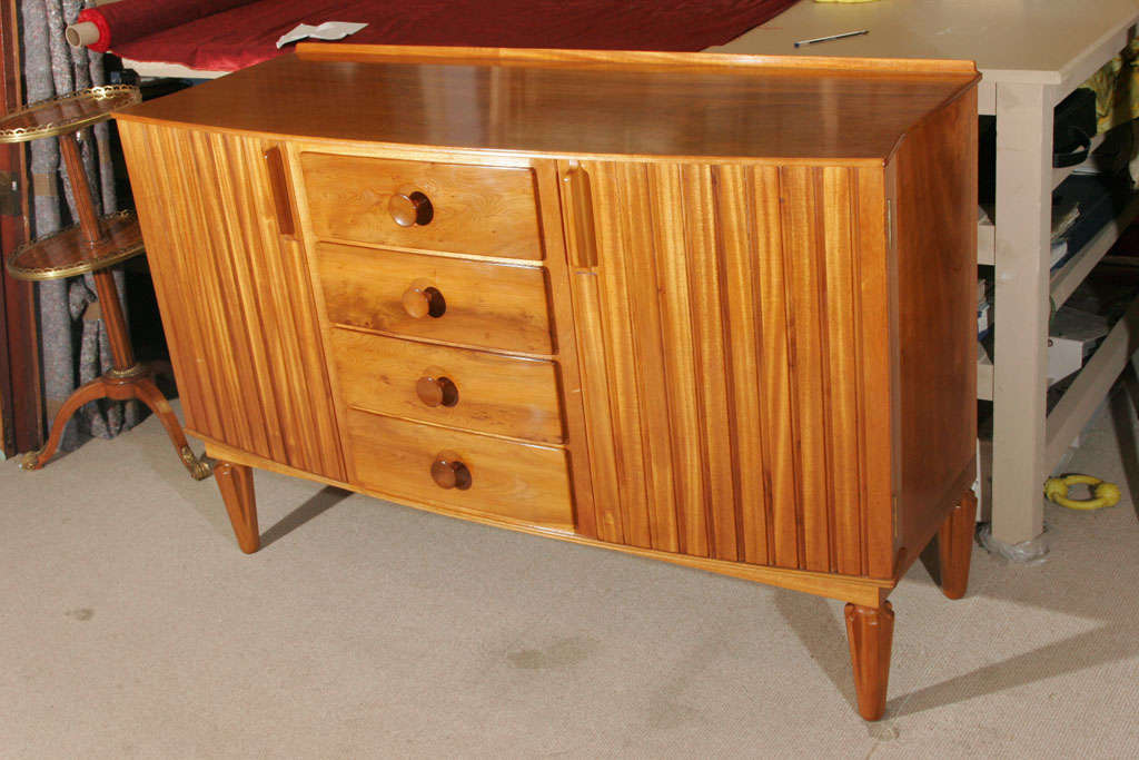 A walnut with mahogany interior sideboard designed by Gordon Russell Ltd.
Four central drawers, with grooved paneled doors either side with fitted cupboards.
England, circa 1940.