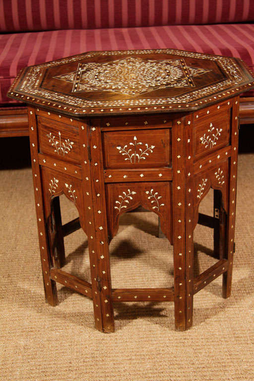The top inlaid with a central star design comprised of ebony and ivory stringing. Inlaid ivory floral motifs are placed in and around the star. The central design surrounded by ivory and ebony geometric and floral borders. The top on a base inlaid