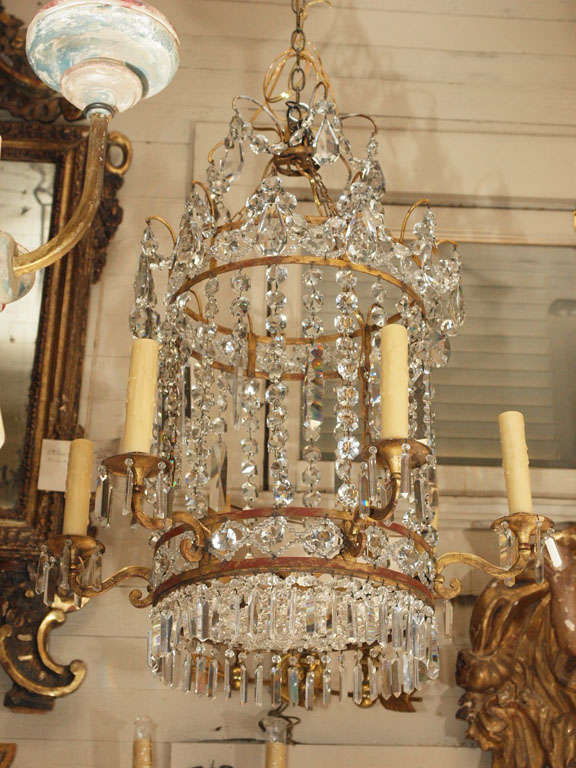 Unusual hanging crystal fixture in the shape of a lantern. High quality crystal on a gilded iron frame. US wired