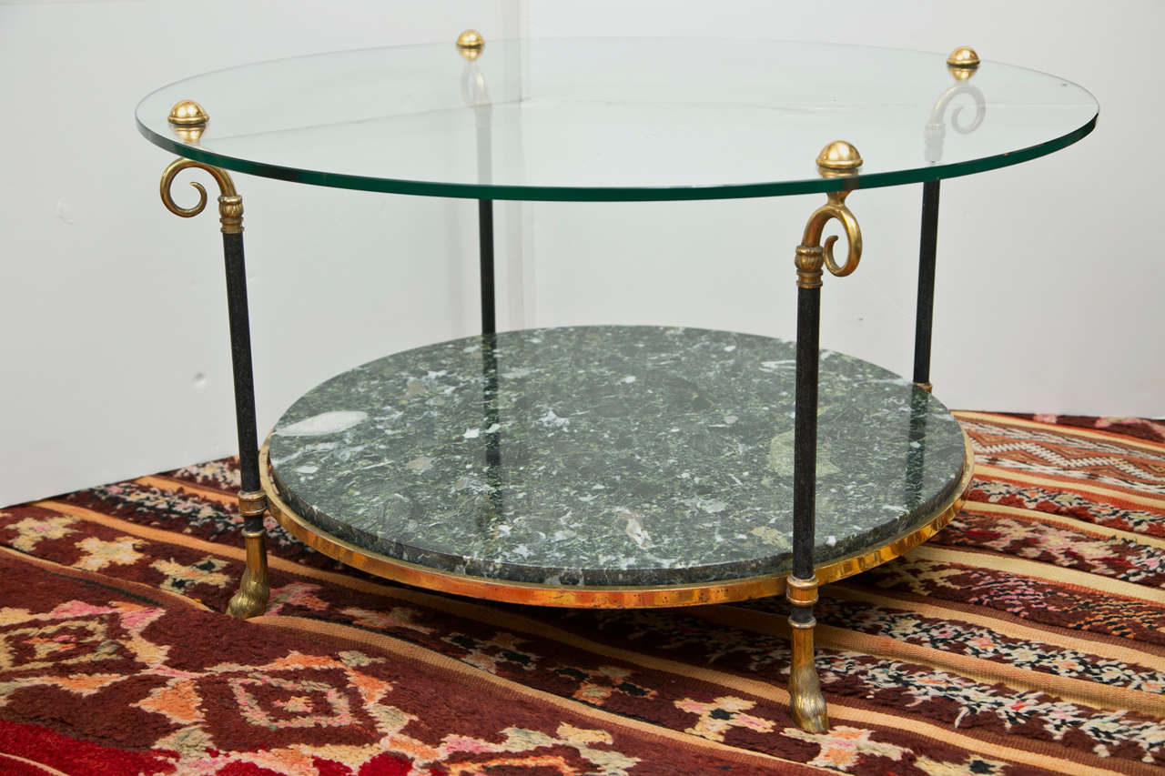 A vintage French cocktail table of solid brass. The lower shelf is a beautiful green and white marble.