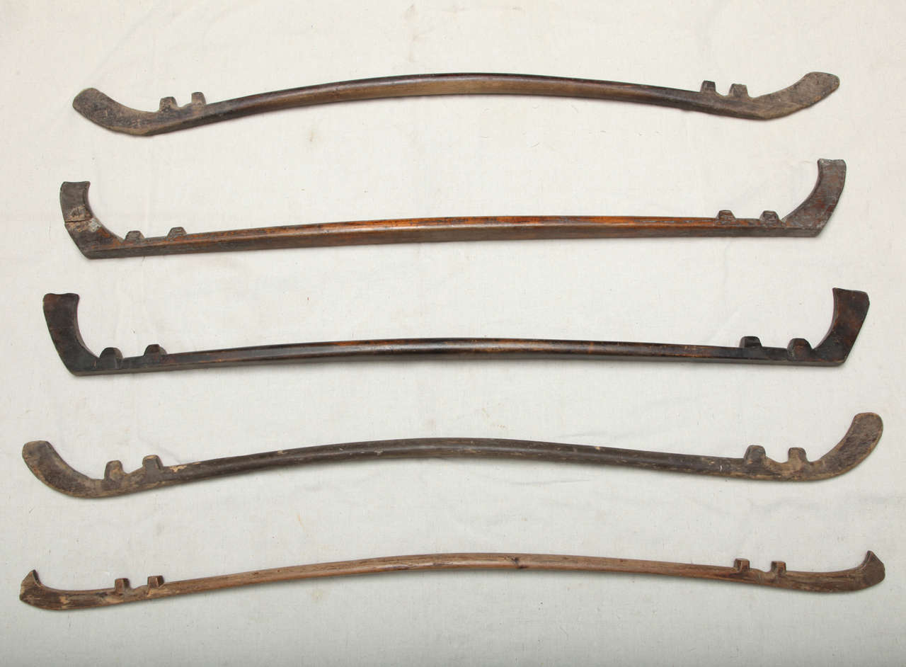 a set of five hand carved Chinese shoulder yokes for carrying water, or goods. Showing years of wear where ropes had rubbed, beautifully carved and extremely light weight. sold only as a set of five. These are rare examples of Chinese folk craft of