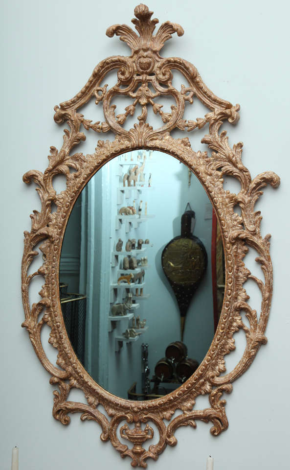 Very fine George III carton pierre oval mirror, in the manner of John Linnell, the leafy feathered cresting over swan neck arches with egg and dart moldings, over foliate and garland swags, the oval frame with ovolo molding and rocaille surround,