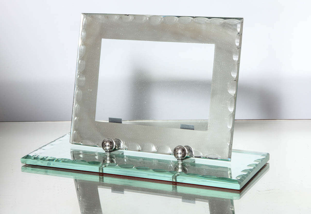 An elegant French mirrored deco frame with scalloped bevel edges on a mirrored base.