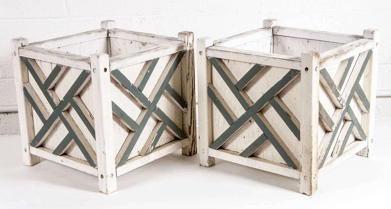 Here is a charming pair of jardinieres. The boxed planters are painted with a raised lattice motif in contrast color. The finish is rustic with slight wear.