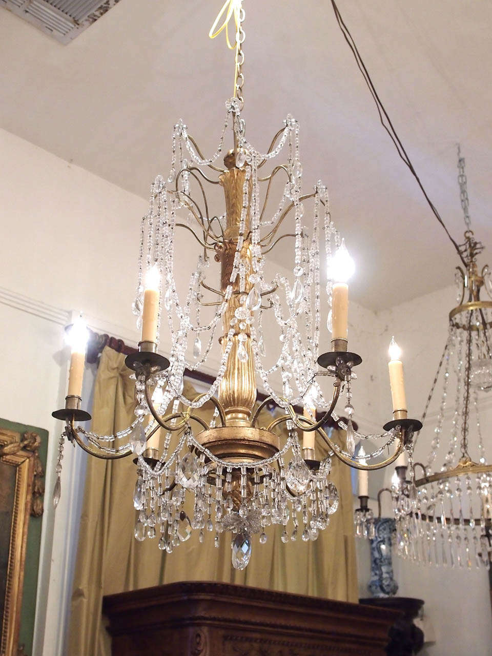 Italian Genovese chandelier with gilt iron arms and gilt wood stem and crystal dressing.