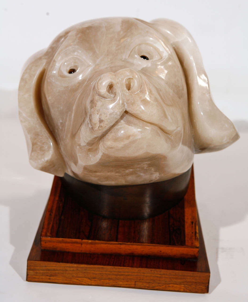 An amazing onyx dog sculpture by Albert Seltzer. It is mounted on a swivelling rosewood stand. The dog has eyes made out of chrysoberyl, commonly known as cat's eye.